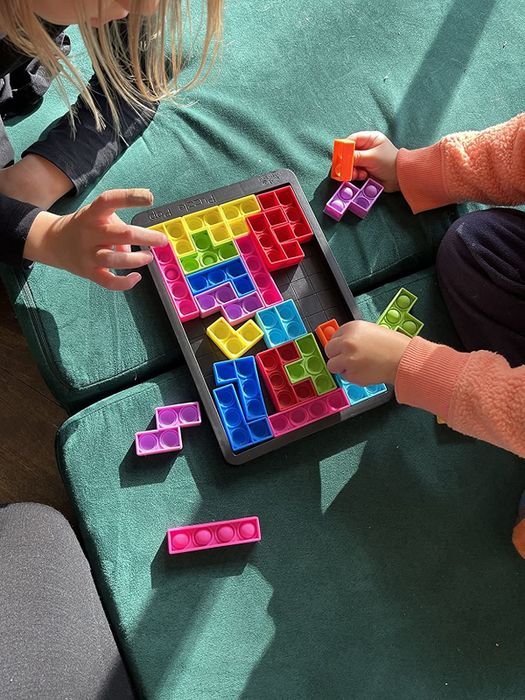A photo of children enjoying a colorful puzzle popper game, shared by the reviewer.