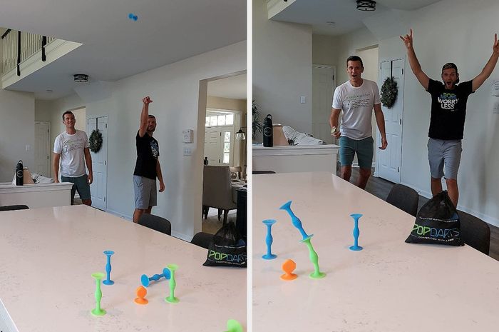 An image showing two people playing a dart game: one with a dart mid-air and the other with a dart landing atop a previously thrown one.