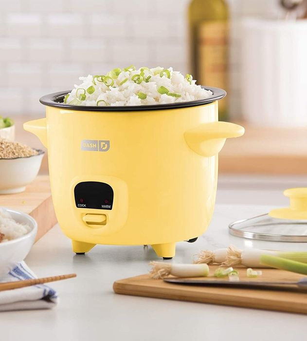 A yellow rice cooker filled with perfectly cooked rice