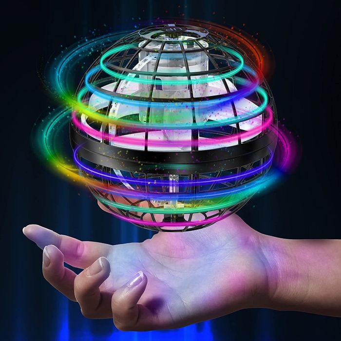 A glowing ball toy hovering just above a hand, captured in the photo.