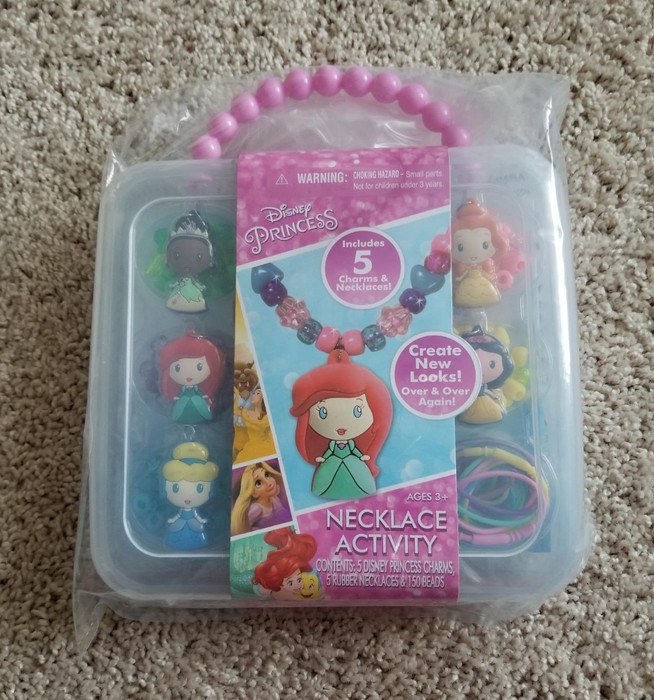 A Disney Princess Necklace Craft Kit designed for ages 3 and up, featuring 5 charms and 5 necklaces to mix and match. Includes beloved characters such as Ariel and Belle