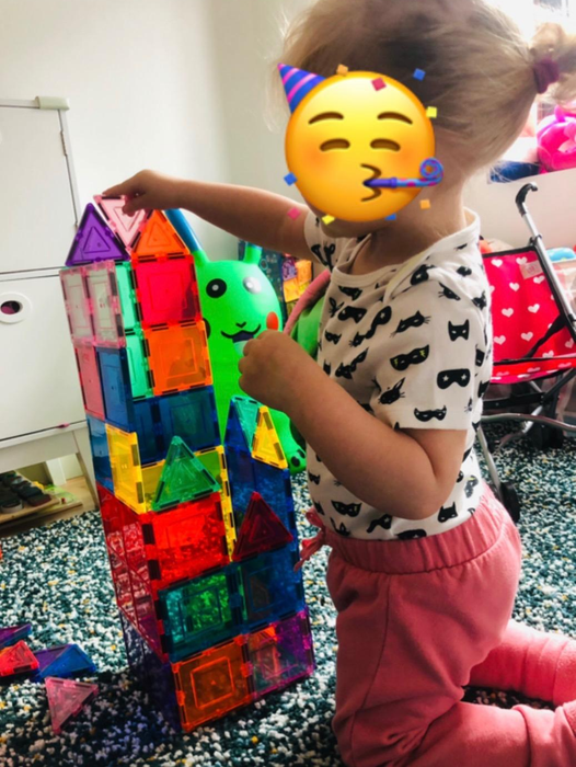 another reviewer's photo of a toddler assembling a house using the magnetic tiles