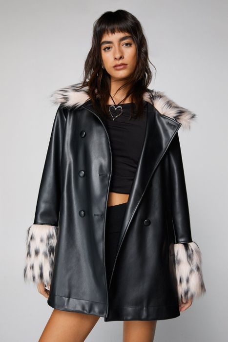 A model wearing a black leather coat adorned with faux fur trim