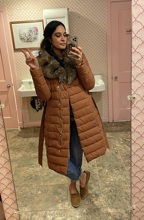 A reviewer is seen wearing the jacket in a warm tan shade.