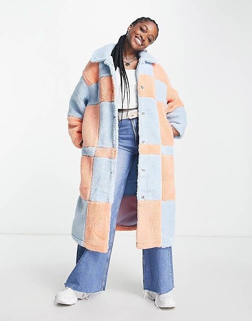 A model showcasing the longline coat with a distinctive checkerboard design