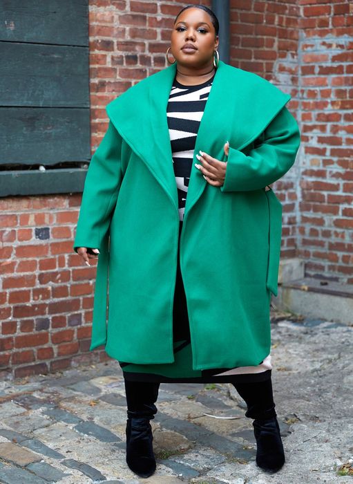A model wearing the green belted coat, viewed from the front