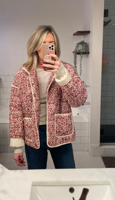 reviewer wearing the jacket featuring a white and red floral design