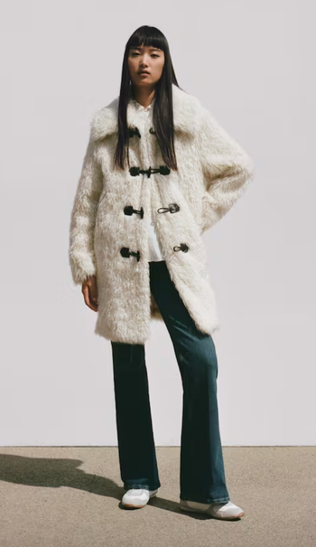 model wearing a white midi coat made of faux fur