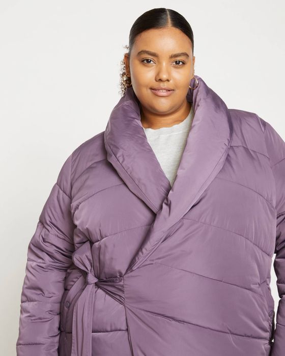 The model showcasing the coat in a striking purple shade