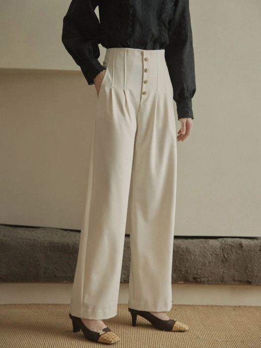 The pants are in a cream color with button detailing down the front.