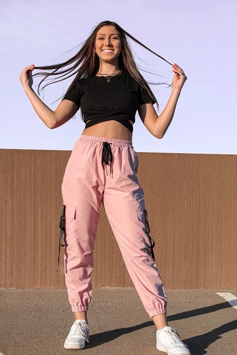A reviewer is seen wearing pink-colored pants.