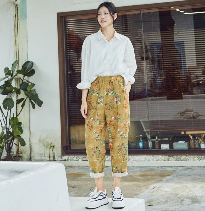 A model showcasing vibrant yellow floral pants.