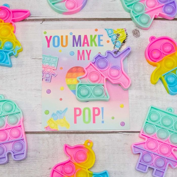 A unicorn-shaped pop-it toy on a card that reads, 'you make my heart pop.'