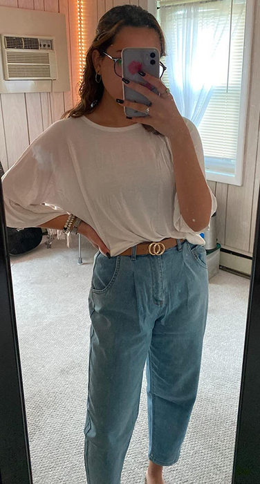 A reviewer is styling light blue jeans with a white top.