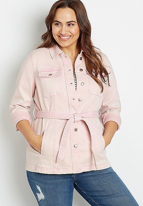 Model showcasing the pink jacket, cinched at the waist with a belt.