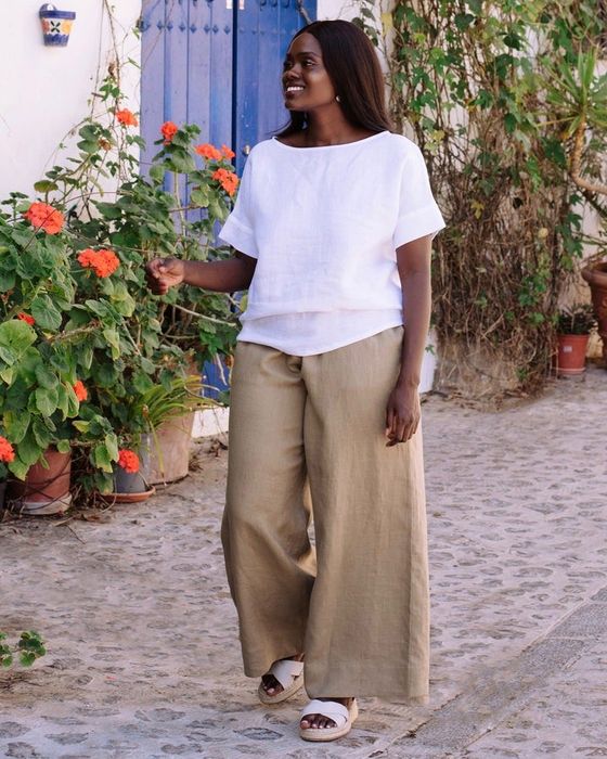 a model showcasing the wide-leg linen pants in a muted dried moss hue