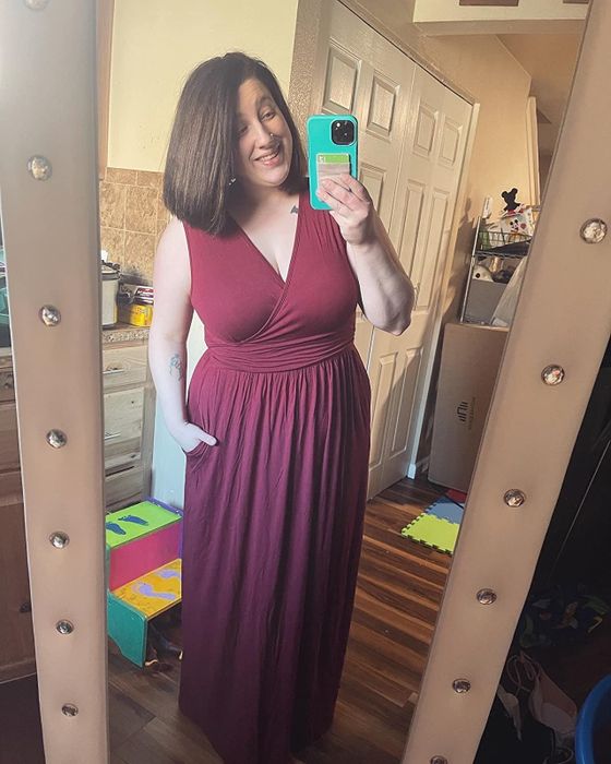 The reviewer is wearing a stunning burgundy dress.