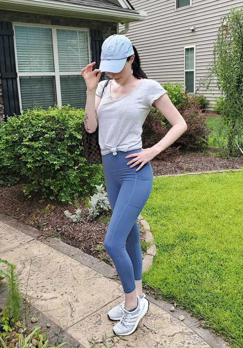 A reviewer styled in steel blue leggings featuring convenient pockets