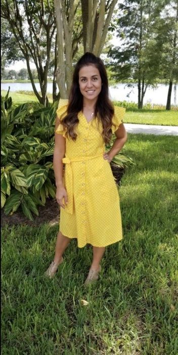 The reviewer is wearing a yellow version of the dress.