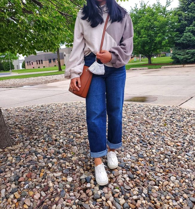 A reviewer styling dark blue jeans.