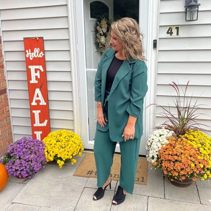 A reviewer is wearing a teal set paired with a black top.