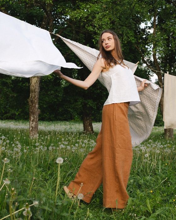 another model styled in the wide-leg linen pants featuring a warm cinnamon tone