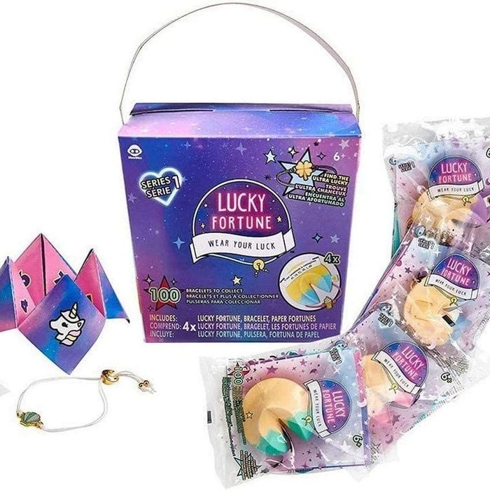 A purple takeout container containing a bracelet, a fortune cookie, and four individually wrapped fortune cookie toys.
