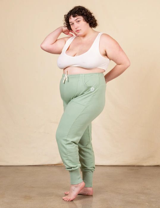 The sweatpants are shown in a light sage green color.