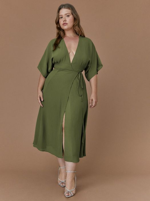 The model is sporting a chic green wrap dress.