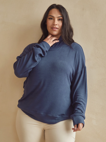 Model wearing the oversized turtleneck sweater in navy.