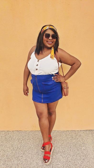 reviewer wearing a white button-down tank top paired with a blue skirt