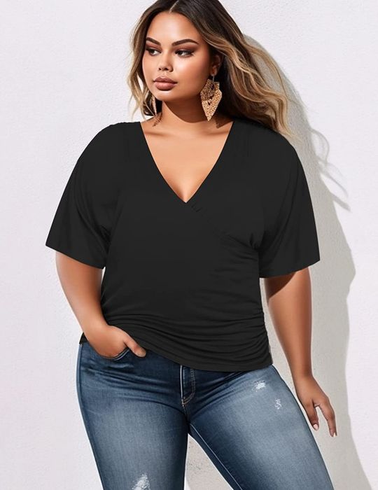 Model styled in a black short-sleeve wrap tunic paired with blue jeans