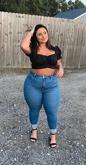 Reviewer rocking a black ruffled blouse paired with jeans