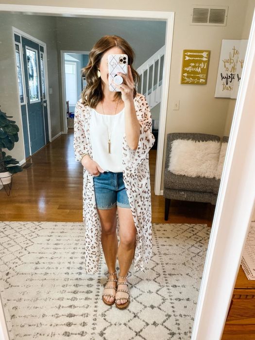 Reviewer layering the cardigan over a shirt and shorts for a casual look