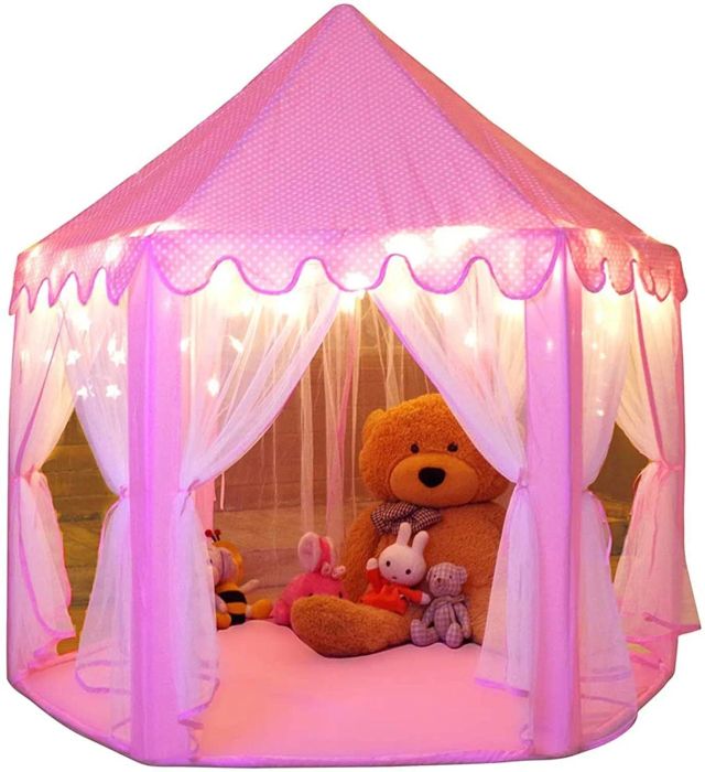 The cozy pink tent glowing with lights, filled with stuffed animals inside for a dreamy playtime experience.
