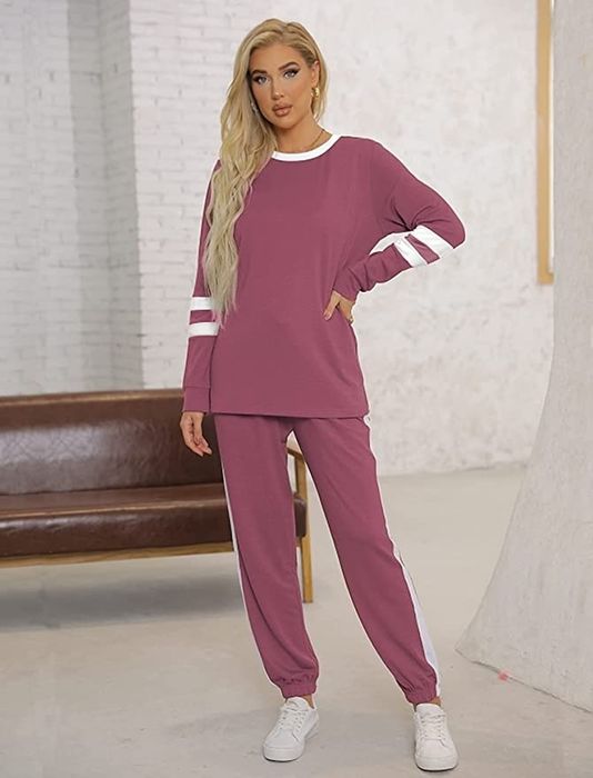 A model wearing the sweatsuit set in a soft pink color.