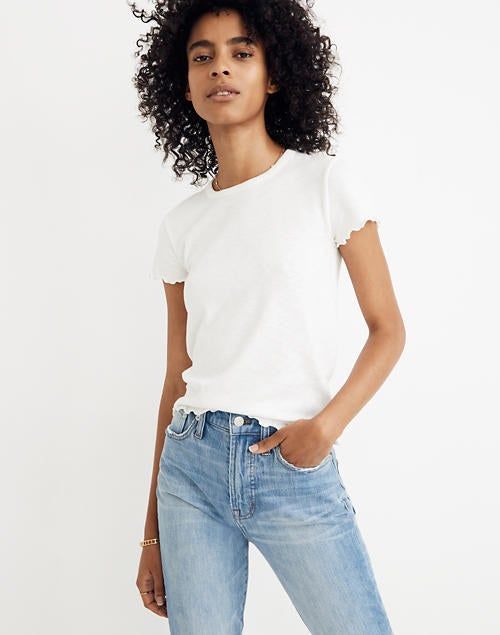 A model showcasing a stylish white baby tee paired with classic jeans.