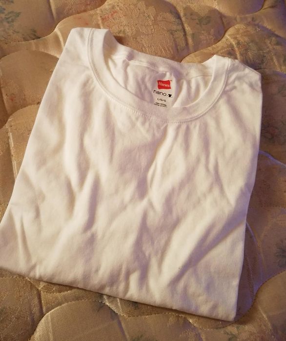 reviewer photo of a white tee neatly folded on a bed
