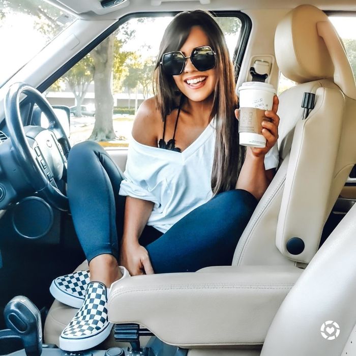 photo of the reviewer wearing the V-neck off the shoulder, holding a coffee cup in a car