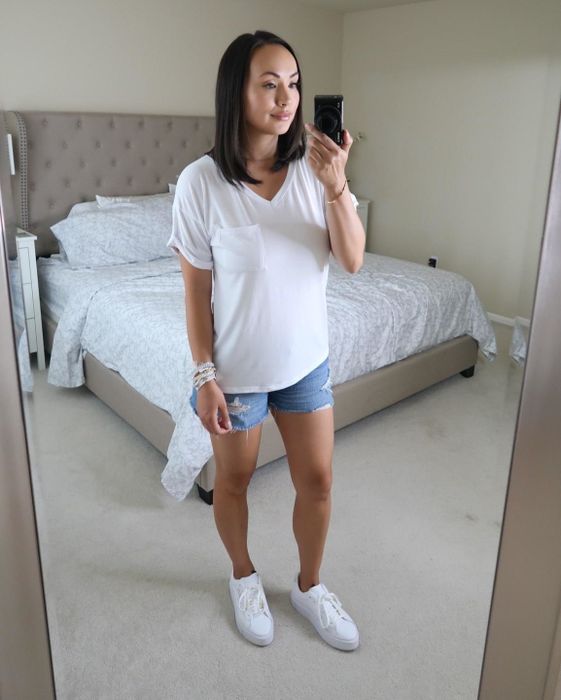 mirror selfie of the reviewer in the white tee paired with denim shorts