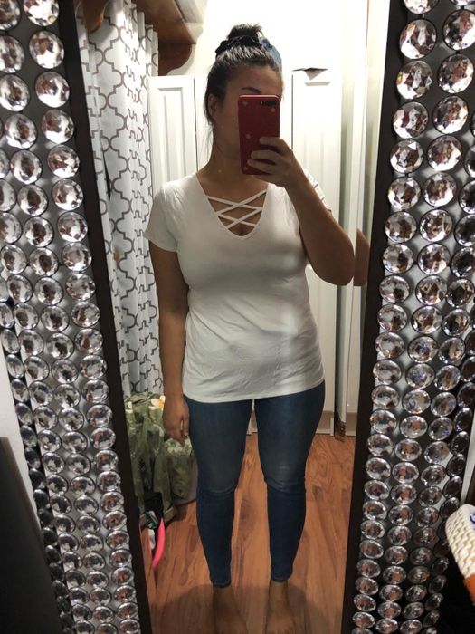 mirror selfie of the reviewer wearing the crisscross white tee