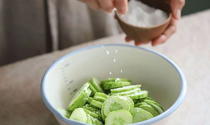 Cho dưa leo vào tô lớn, thêm một ít muối hoặc bột canh.