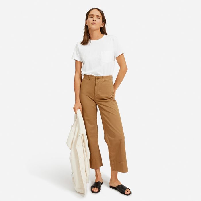 model showcasing a white t-shirt paired with cutoff pants and slides