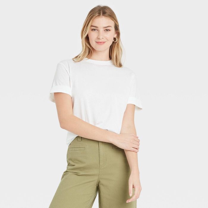 model dressed in a cuffed white tee paired with green pants
