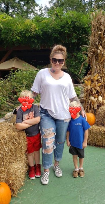 A photo of a reviewer wearing the t-shirt alongside their two sons, with their faces blurred for privacy.
