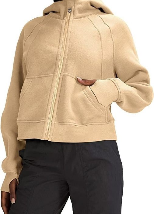 A model styling a beige sweatshirt for a laid-back look.