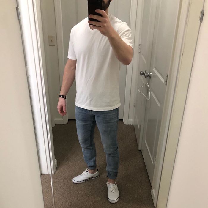A mirror selfie of a reviewer wearing the white tee paired with jeans.