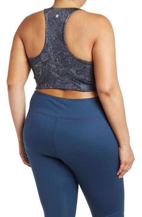 A back view of the model wearing the same navy blue floral longline sports bra.