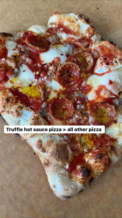 a mouthwatering pepperoni pizza topped with truffle sauce, accompanied by a caption