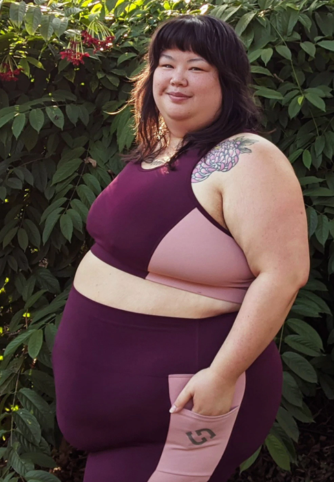 A model wearing a colorblock light pink and burgundy sports bra.